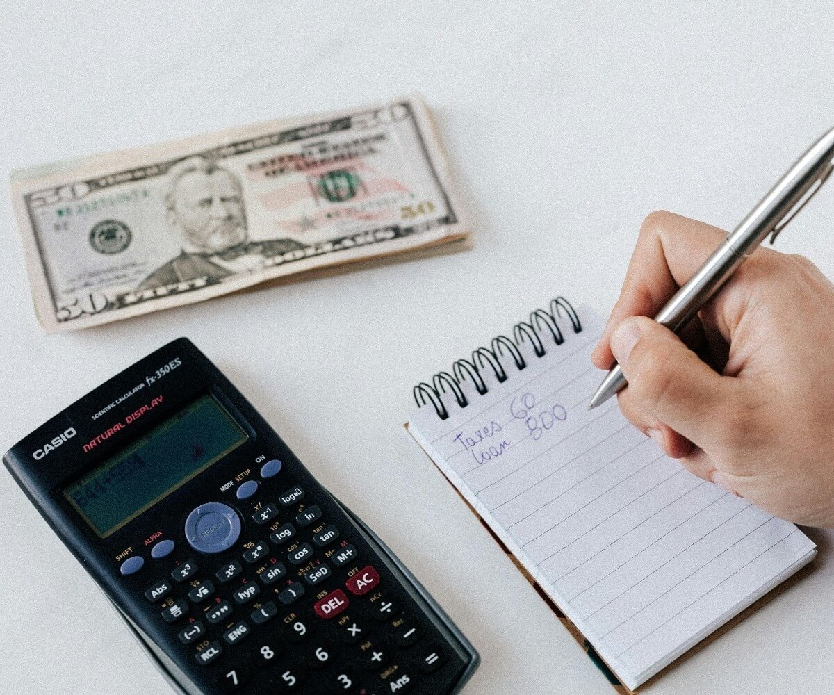 Financial planning for medical grants with money, a calculator, and a notepad.